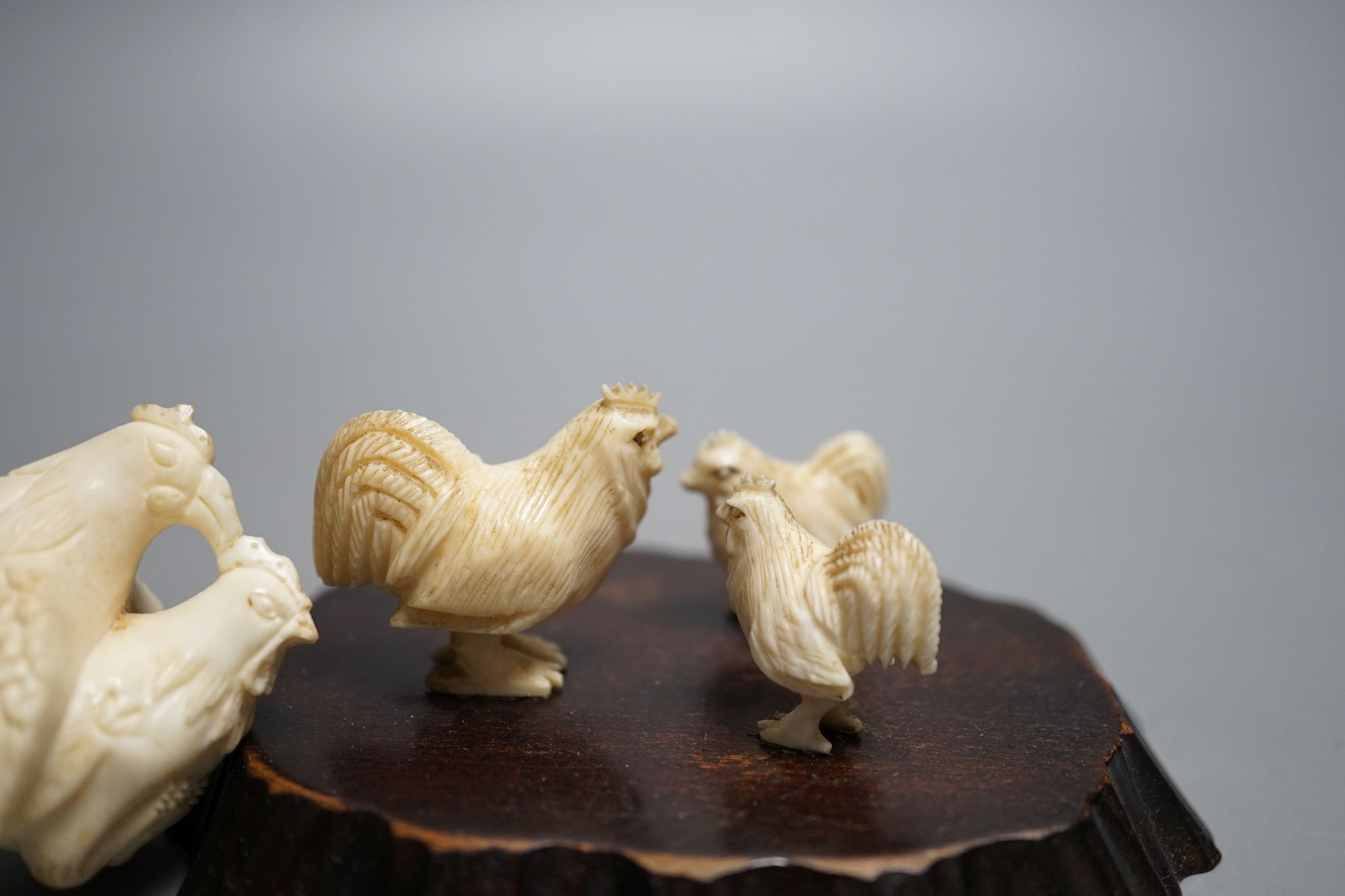 A Japanese Meiji period ivory bird with mother of pearl eyes, a Japanese group of three chickens and Japanese copulating chickens